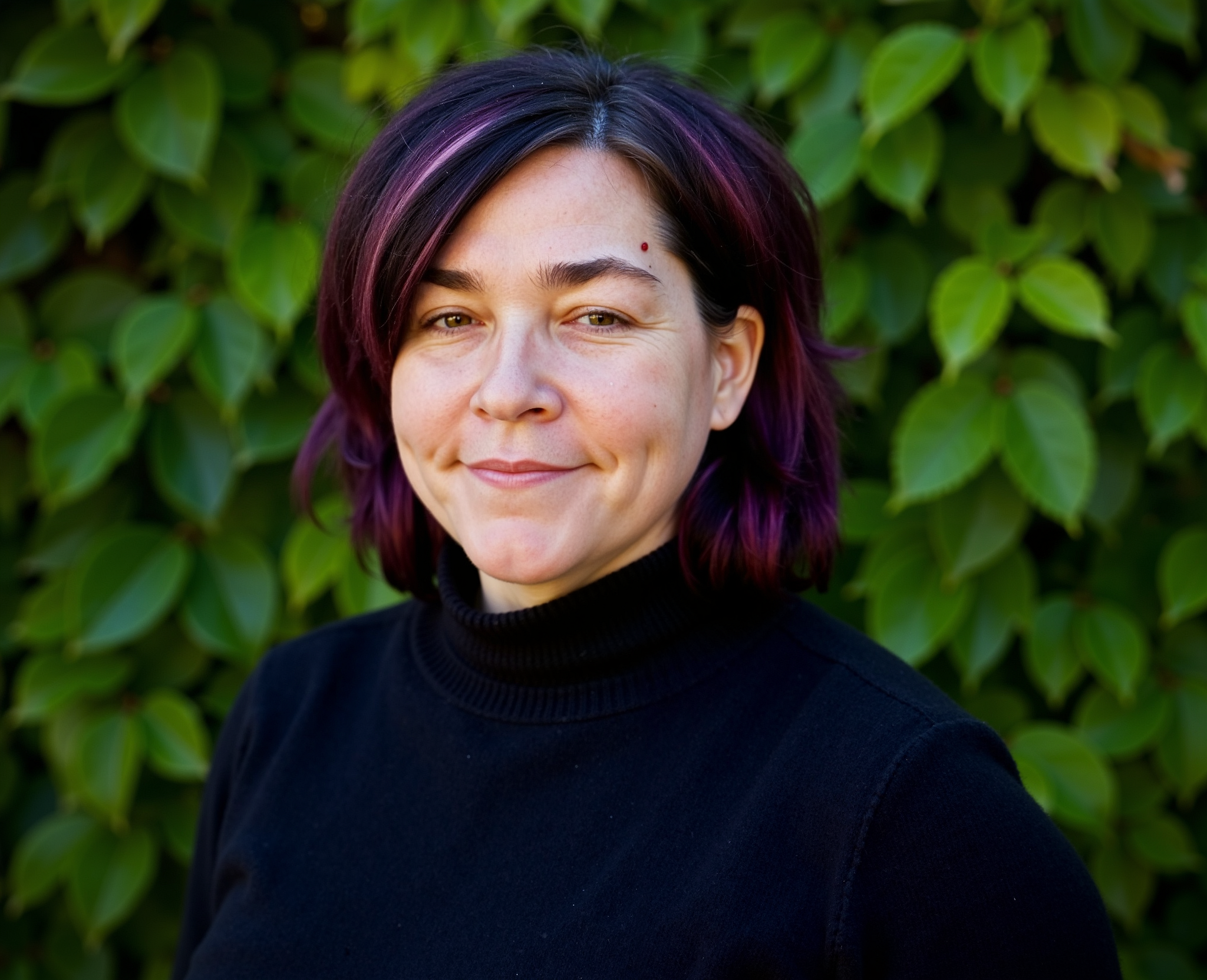 A professional headshot of a digital marketing and SEO consultant standing in front of green foliage, representing business strategy and growth in the United States.