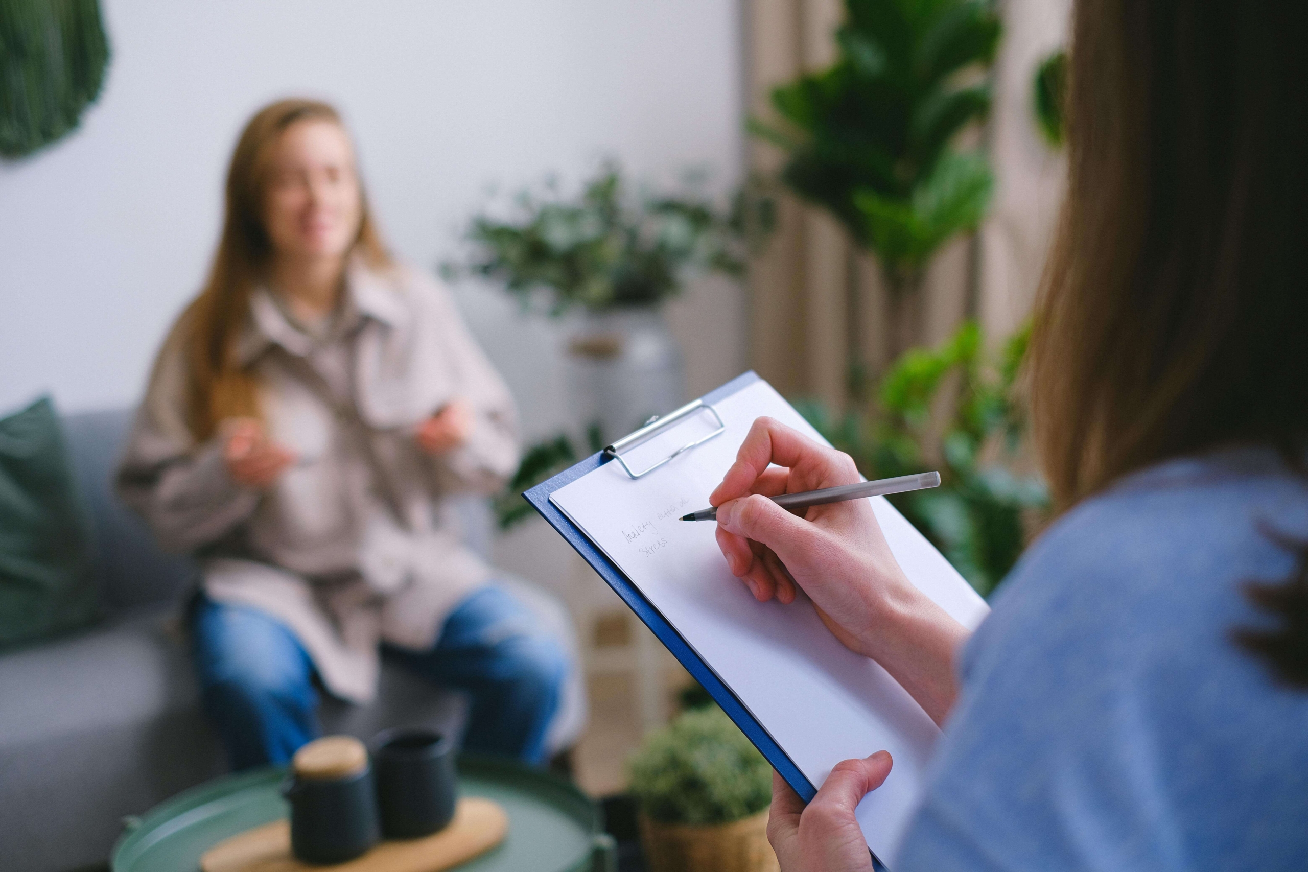A therapist taking notest in a session. Want to attract more clients and grow your practice? Find out how SEO for mental health professionals can expand your reach and help attract clients who are looking for your services.