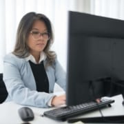 A focused woman works at a desktop computer. Building a strong online presence takes consistent effort and the right strategy behind every click. SEO for therapists helps ensure that effort translates into real visibility and a steady stream of new clients.