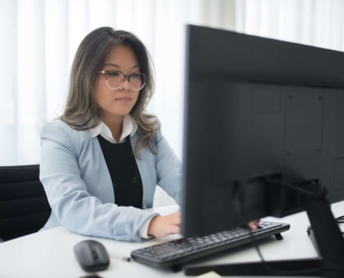 A focused woman works at a desktop computer. Building a strong online presence takes consistent effort and the right strategy behind every click. SEO for therapists helps ensure that effort translates into real visibility and a steady stream of new clients.