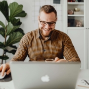 A smiling man with glasses working on a laptop at a bright, organized home office desk. Ready to show up on Google? Simplified SEO Consulting delivers real SEO help for therapists who are ready to grow.