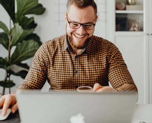 A smiling man with glasses working on a laptop at a bright, organized home office desk. Ready to show up on Google? Simplified SEO Consulting delivers real SEO help for therapists who are ready to grow.