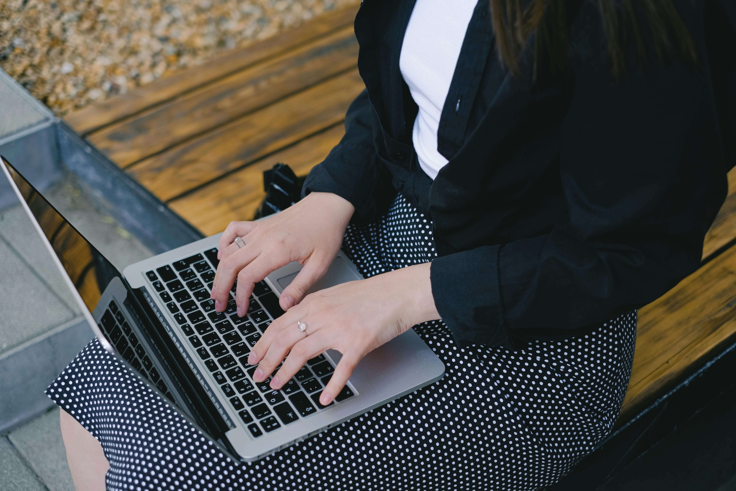 Close-up of a woman typing on a laptop, representing work on SEO for online therapy services.