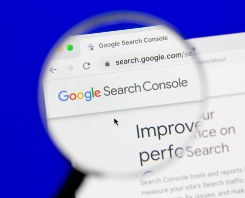 A magnifying glass zooms in on the Google Search Console homepage on a computer screen. Understanding tools like GSC is a key part of technical SEO services for therapists and helping professionals.