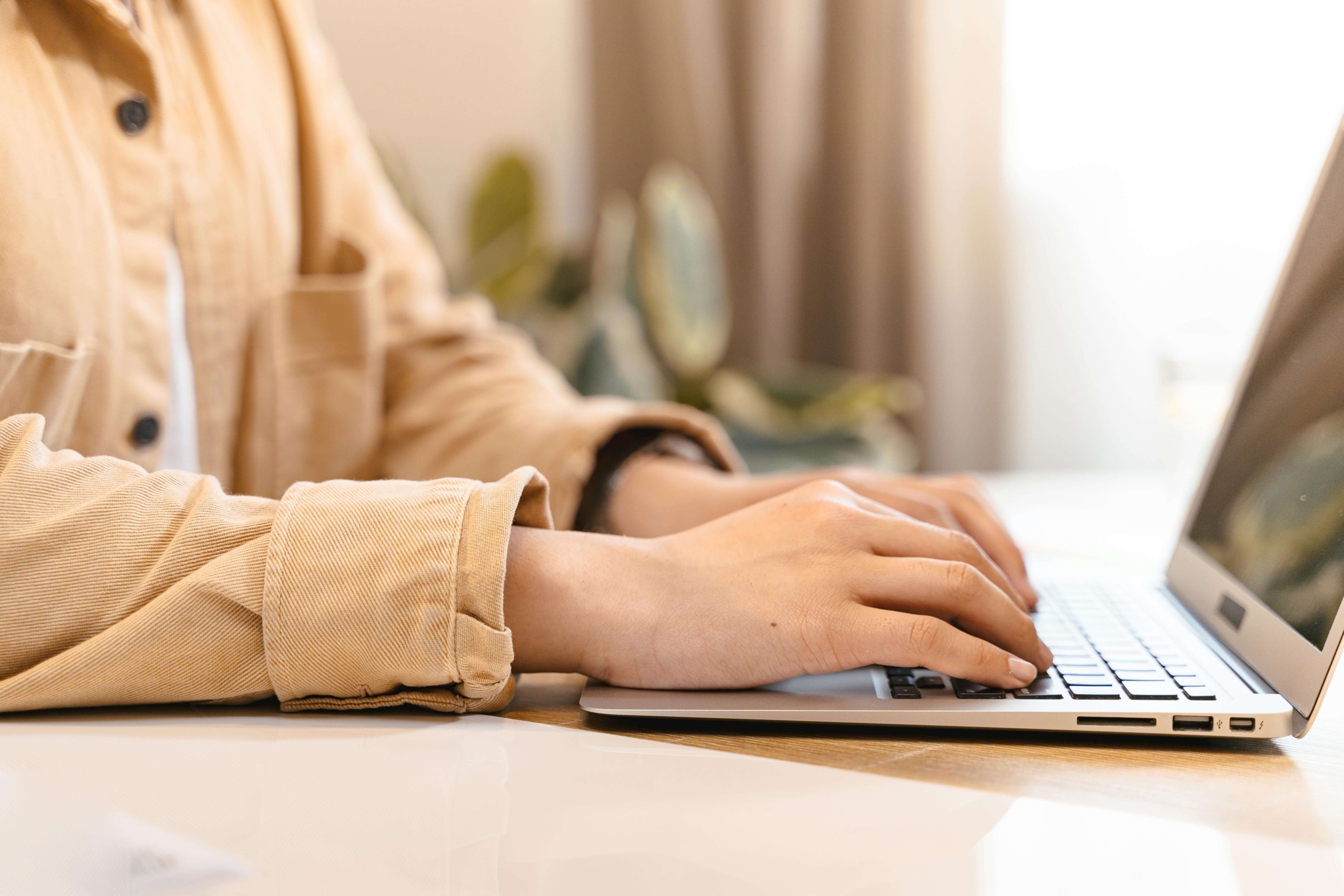 Close-up of a person working on a laptop, symbolizing digital planning and learning involved in SEO help for therapists.