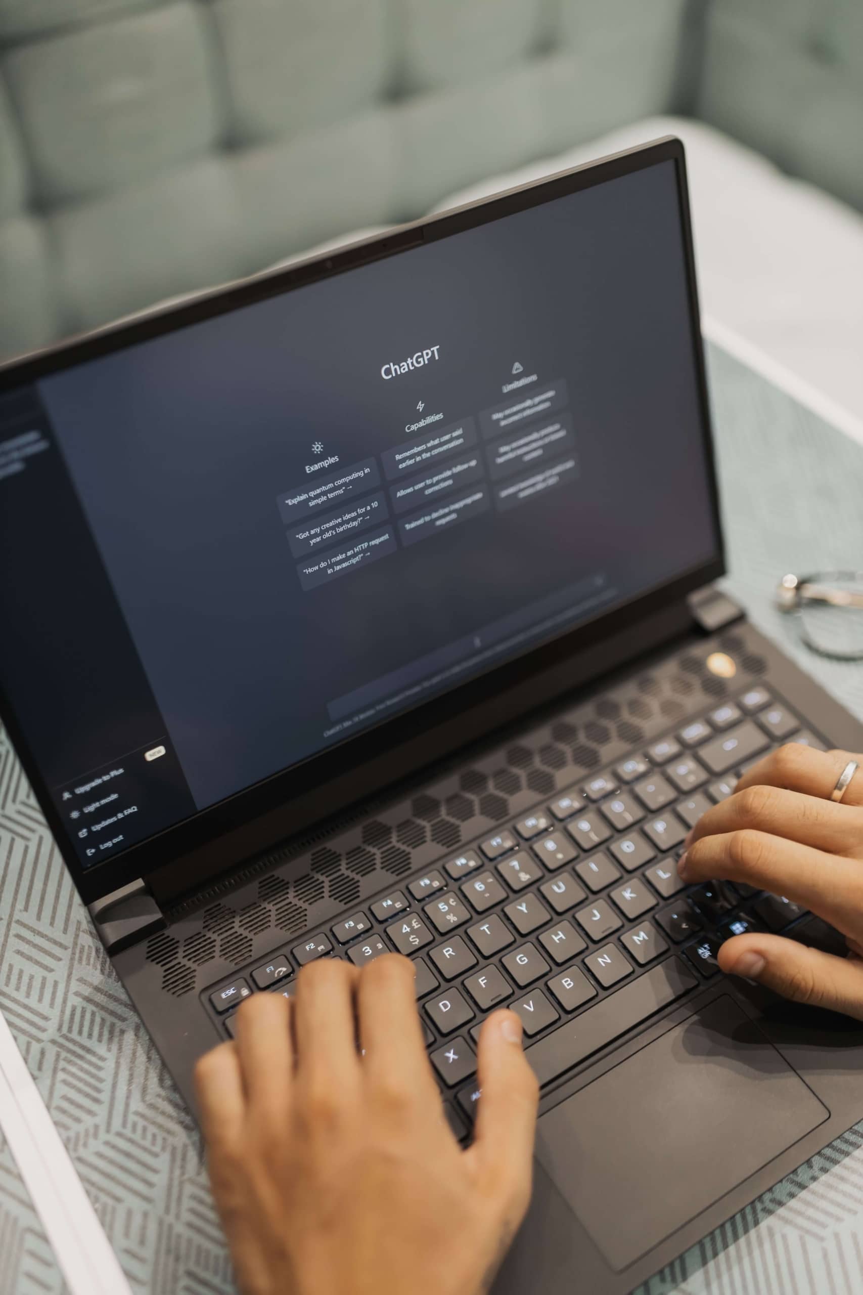 A close up of hands typing on a dark laptop with the ChatGPT interface visible on the screen, resting on a patterned surface with glasses nearby. AI is changing how people search online, but strong SEO for therapists is still what helps your practice show up in the moments that matter.