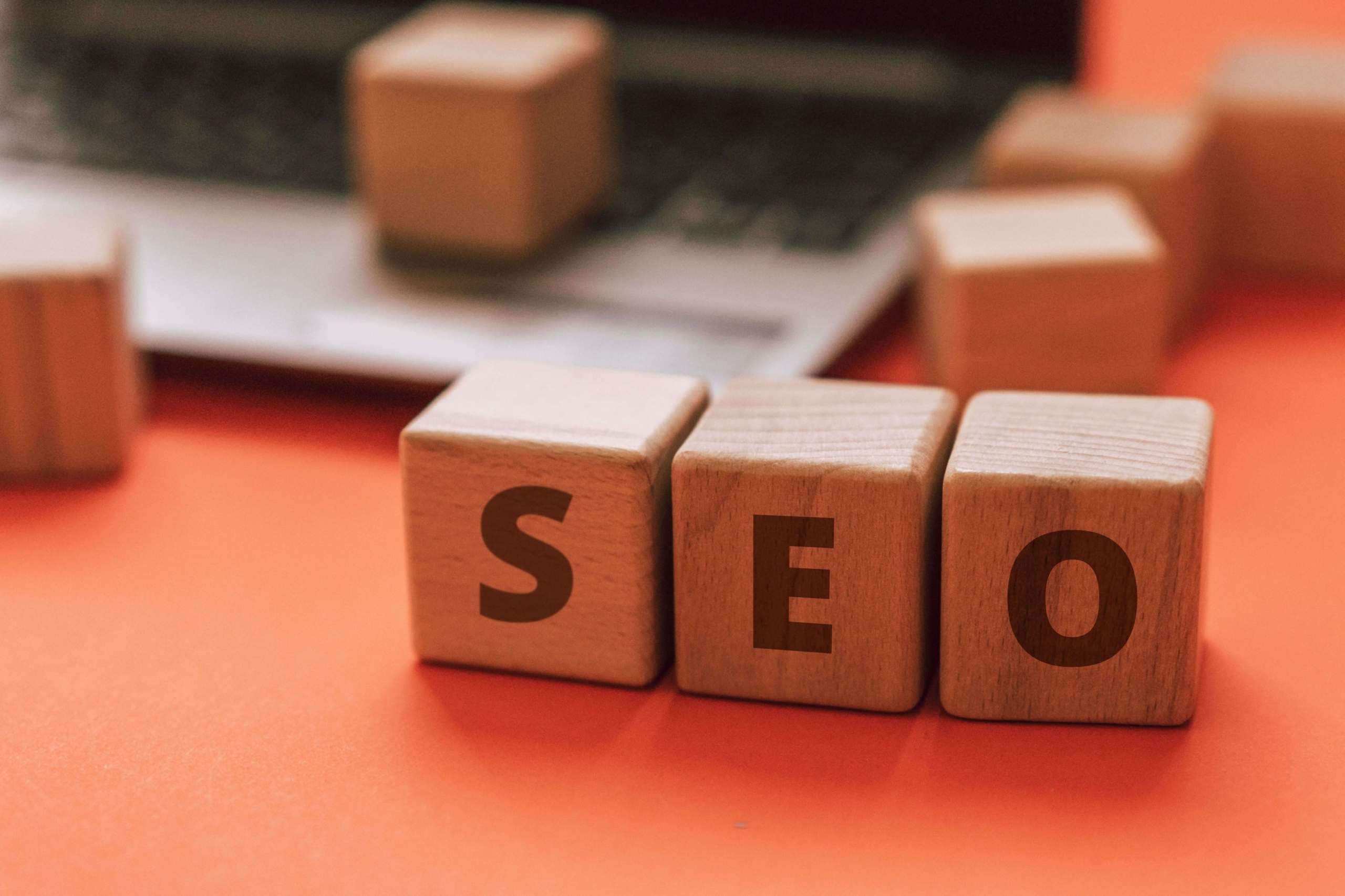 Wooden blocks spell “SEO” on a desk beside a laptop. What role does high-quality content play in helping therapy websites rank and attract ideal clients? Therapist Seo focuses on creating meaningful content that supports visibility.
