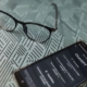 A smartphone displaying a ChatGPT conversation sits on a desk next to a pair of glasses. AI tools like ChatGPT can be helpful starting points for content creation, but therapists and helping professionals need more than AI output alone to build an effective SEO for therapists strategy.