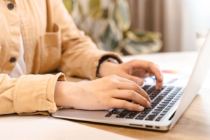 An individual typing on a laptop in a bright room. If social media marketing isn't your thing, Simplified can help. We offer social media management for therapists.