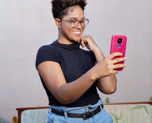 A Black woman standing, taking a selfie with her phone. If your social media isn't reaching the right people, it may be time for a social media manager. Learn how Simplified SEO can help.
