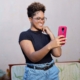 A Black woman standing, taking a selfie with her phone. If your social media isn't reaching the right people, it may be time for a social media manager. Learn how Simplified SEO can help.
