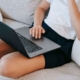 Person sitting on a couch with a laptop, symbolizing the ongoing work of growing a therapy practice through SEO for therapists.