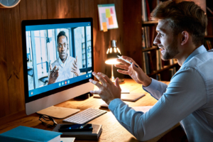 A man engages in an animated video call with a consultant on his desktop computer. Working with an SEO specialist who understands the helping professions is one of the most effective ways for therapists and counselors to build a strategy that goes beyond what AI alone can produce. 