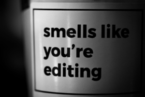 Black and white close-up of a label reading 'smells like you're editing,' representing how thoughtful editing, SEO formatting, and content optimization turn a rough draft into content AI and readers can easily understand.