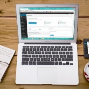 Laptop displaying a WordPress dashboard on a wooden desk next to a notebook, phone, and coffee, representing how good content structure and AI-friendly content start with organizing your website pages clearly.