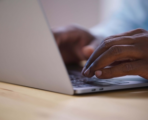Close-up of someone typing on a laptop, representing content creation and the role SEO plays in helping information get discovered through how search engines work.