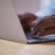 Close-up of someone typing on a laptop, representing content creation and the role SEO plays in helping information get discovered through how search engines work.