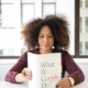 Woman reading a book titled 'What Would Google Do?' at a desk, representing how understanding Google's AI content policy and AI content SEO helps you create content that ranks well.